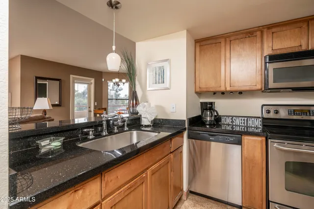 a kitchen with granite countertop a sink a stove and cabinets