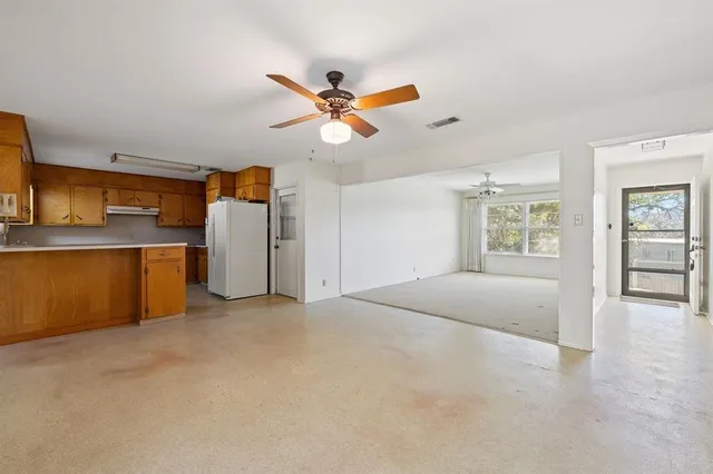 a view of empty room with wooden floor and window
