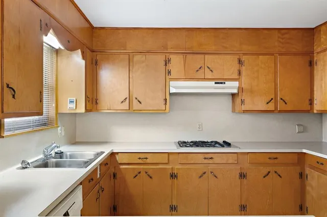a kitchen with stainless steel appliances granite countertop a sink and cabinets