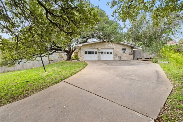 a front view of a house with a yard and trees