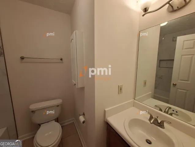 a bathroom with a toilet sink and mirror