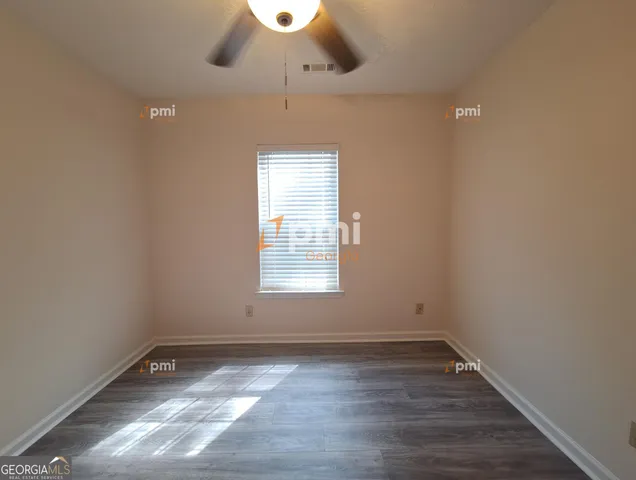 en empty room with wooden floor and windows