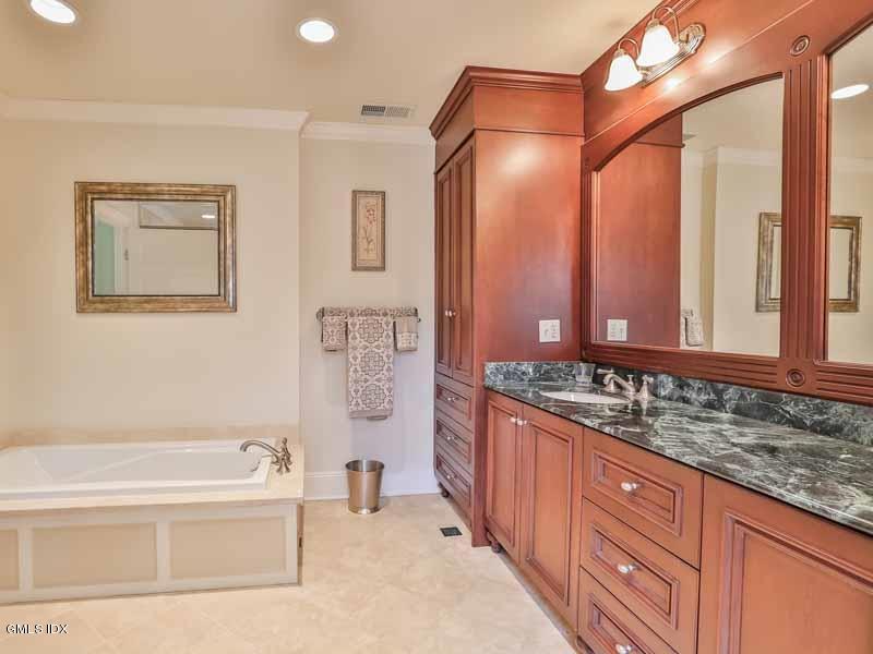385 Middlesex Road Darien, CT 06820 - Photo 21 of 28 a bathroom with a granite countertop tub sink and mirror