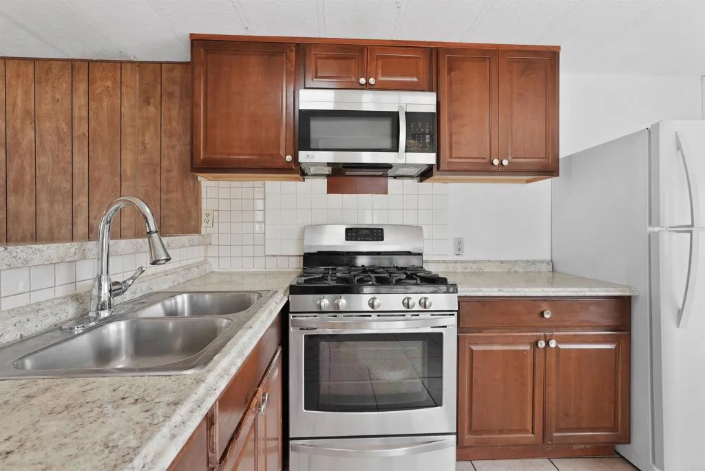 1455 Alturas Street, Unit 41 Fallbrook, CA 92028 - Photo 24 of 52 a kitchen with stainless steel appliances granite countertop a stove microwave and sink