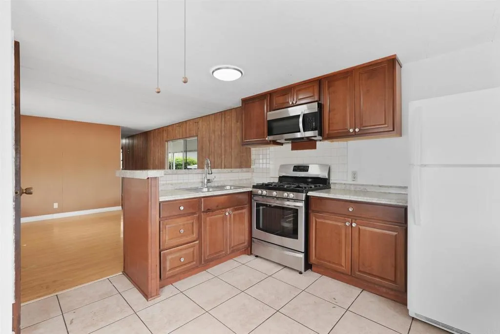 1455 Alturas Street, Unit 41 Fallbrook, CA 92028 - Photo 26 of 52 a kitchen with stainless steel appliances granite countertop a stove a sink and a refrigerator