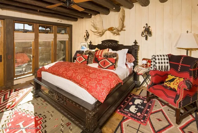 a spacious bedroom with a bed and wooden floor