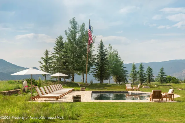 a view of a house with a yard and potted plants