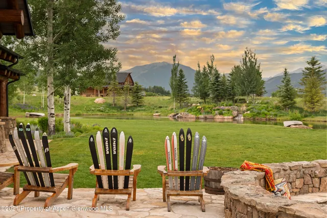 a view of a lake with lawn chairs and a table