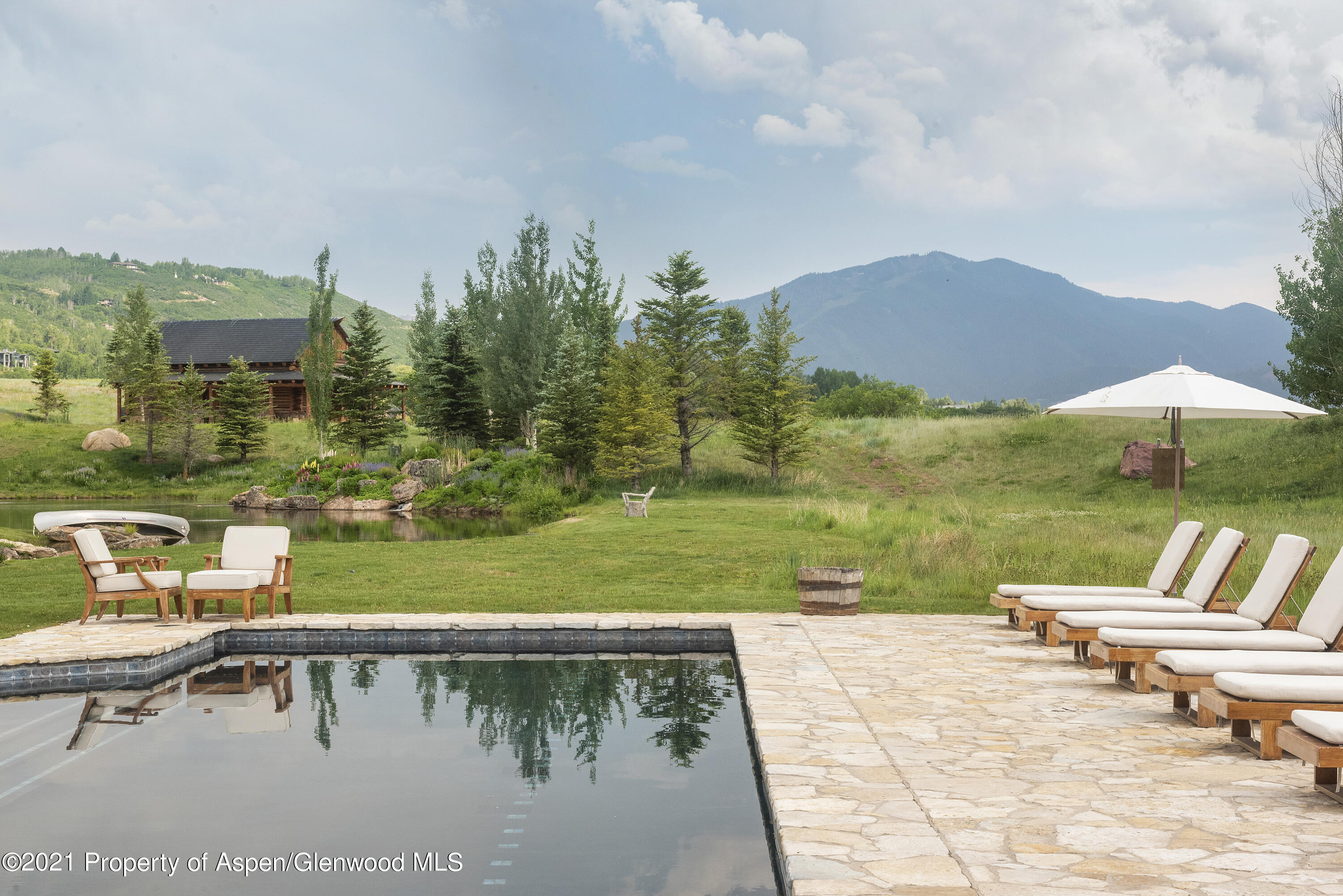 1100 McLain Flats Road Aspen, CO 81612 - Photo 44 of 50 a view of a swimming pool with a lounge chairs