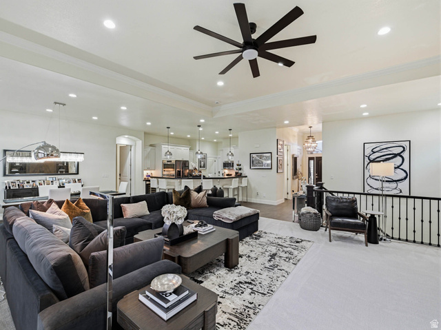 1154 Sunset Dunes Way Draper, UT 84020 - Photo 13 of 50 Living area featuring arched walkways, a ceiling fan, ornamental molding, carpet flooring, and hanging lights