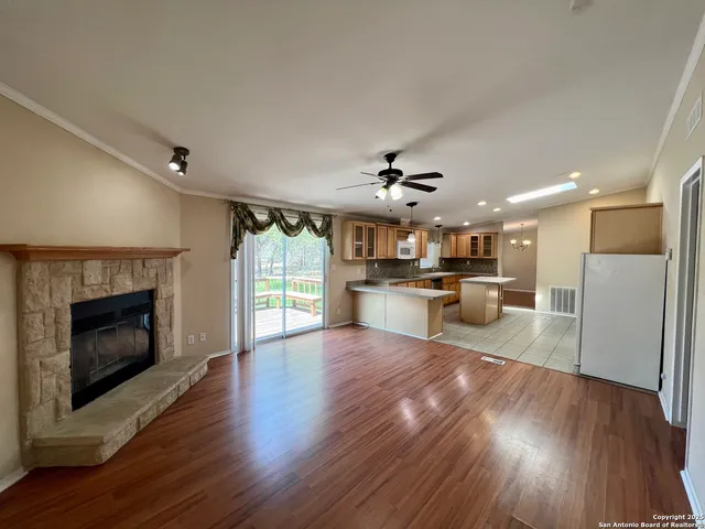 a view of kitchen with kitchen island wooden floor and stainless steel appliances