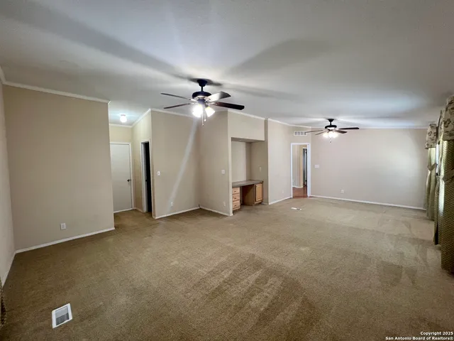 an empty room with a ceiling fan and a window