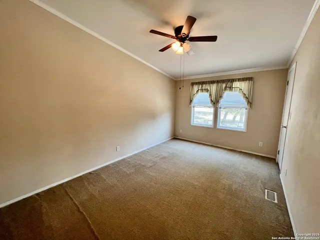 an empty room with windows and ceiling fan