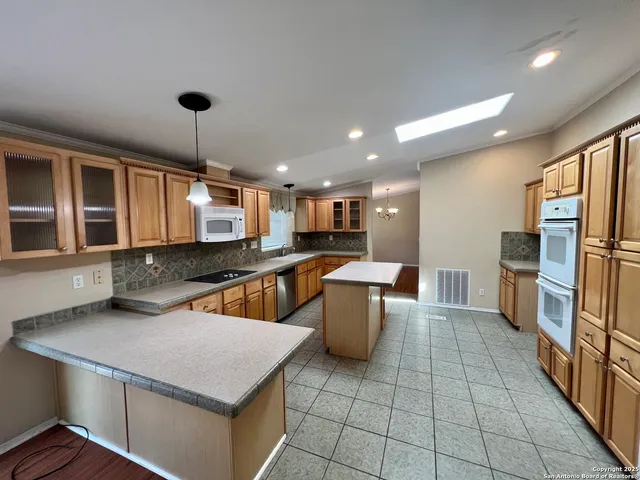 a kitchen with stainless steel appliances wooden floor dining table and chairs