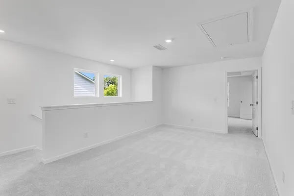 a view of an empty room with window and wooden floor