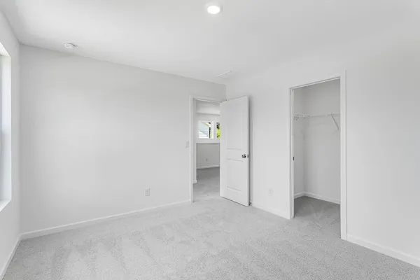an empty room with windows and bathroom