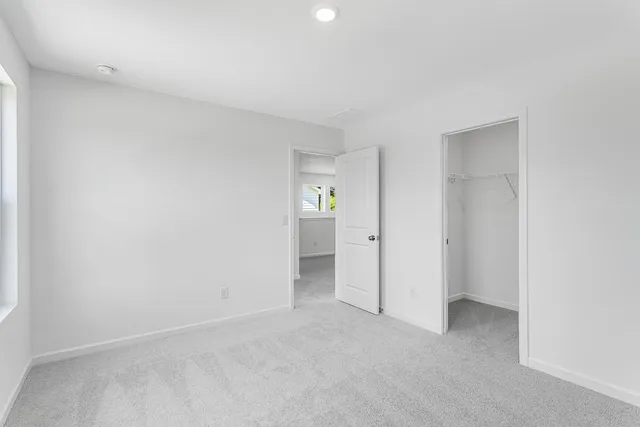 an empty room with windows and bathroom