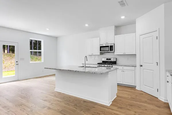 a kitchen with stainless steel appliances granite countertop a stove a sink and a refrigerator