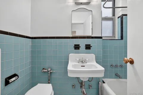 a bathroom with a sink a toilet and mirror