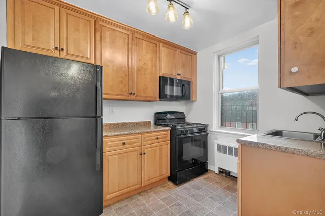 a kitchen with stainless steel appliances granite countertop a refrigerator sink stove microwave and cabinets