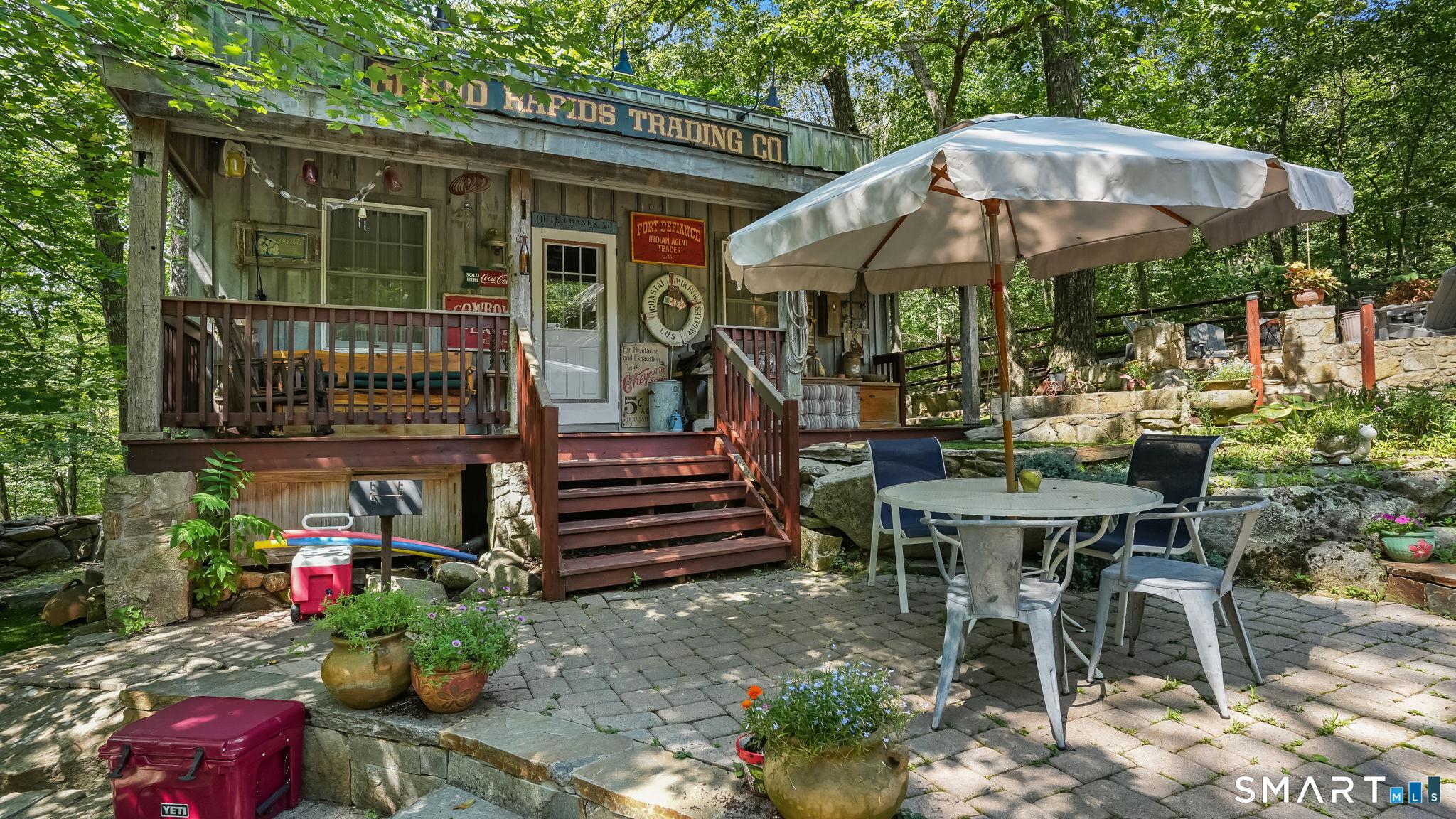 142 Seventy Acre Road Redding, CT 06896 - Photo 27 of 40 a view of a patio with a table and chairs under an umbrella