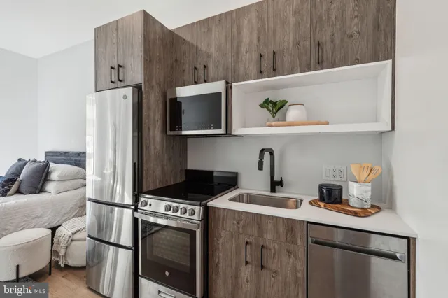 a kitchen with stainless steel appliances a stove a microwave and refrigerator