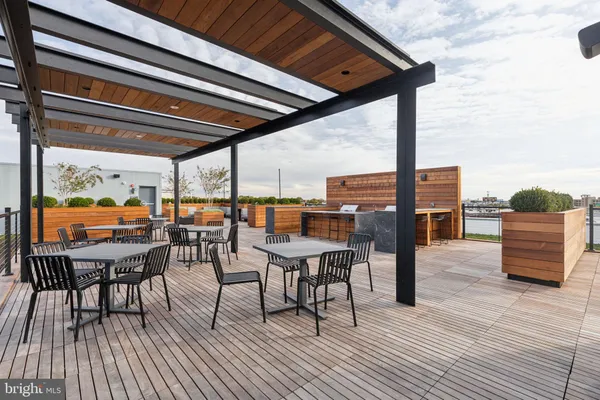a terrace of a house with barbeque oven and seating space