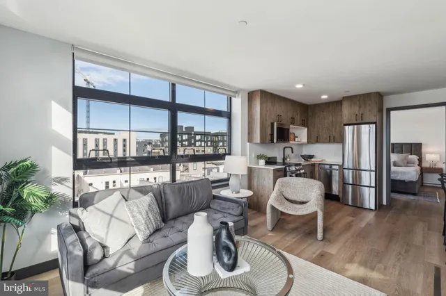 a open kitchen with stainless steel appliances a stove a sink dishwasher a microwave oven with a dining table and chairs