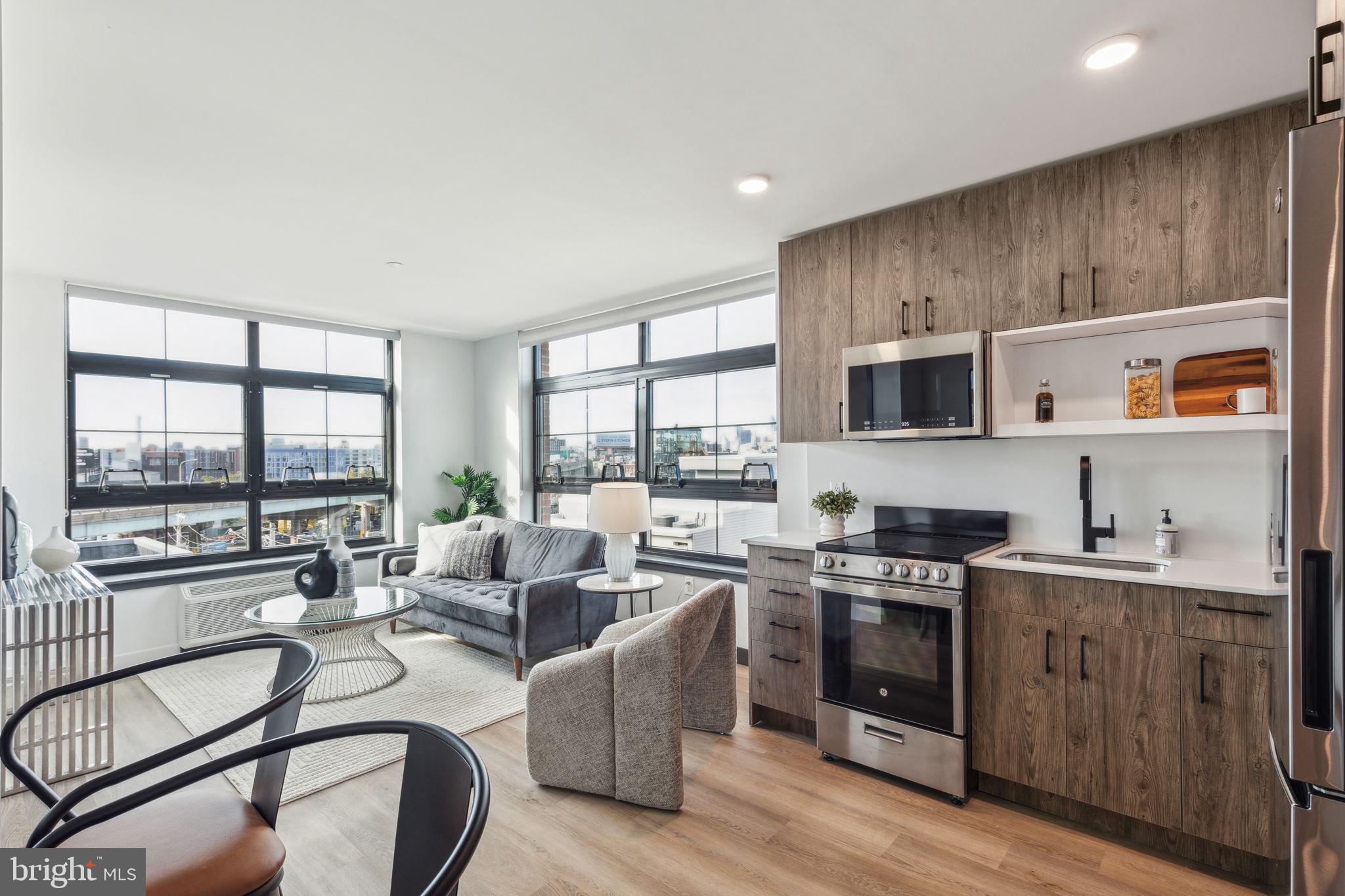 1122 Frankford Avenue, Unit STUDIO A2 Philadelphia, PA 19125 - Photo 31 of 45 a open kitchen with stainless steel appliances a stove a sink dishwasher a microwave oven with a dining table and chairs