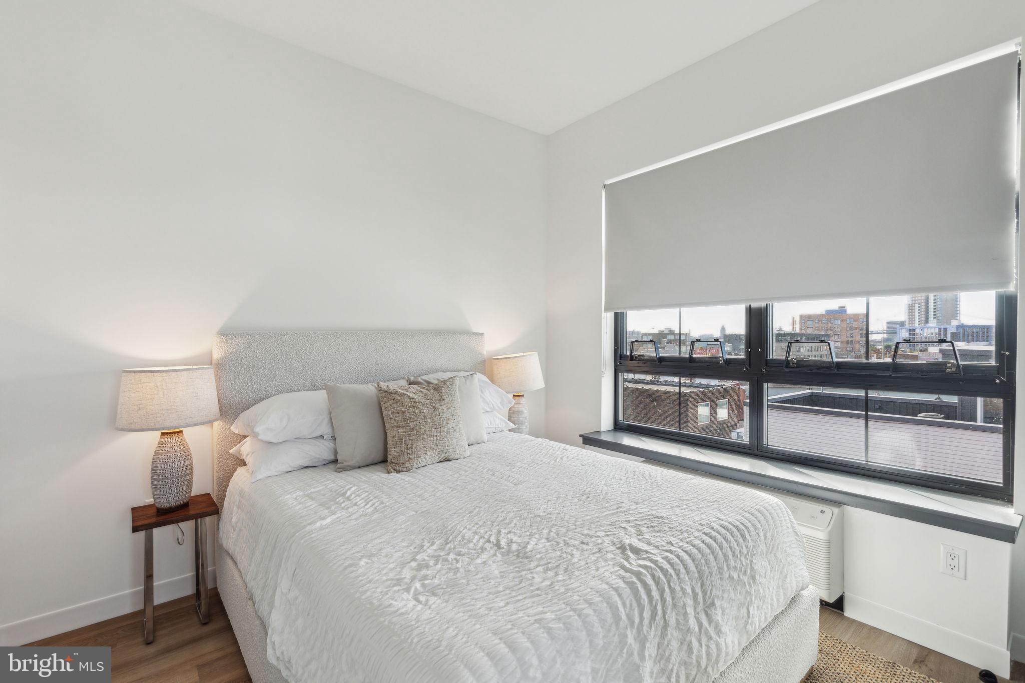 1122 Frankford Avenue, Unit STUDIO A2 Philadelphia, PA 19125 - Photo 34 of 45 a bedroom with a large bed and a large window