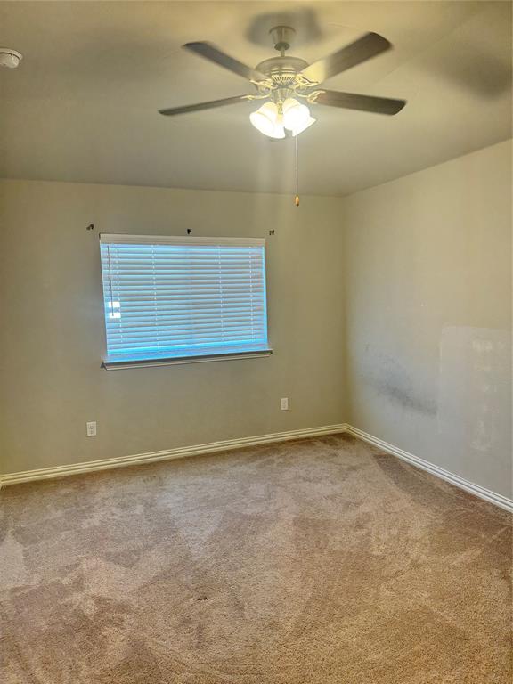 4475 Samarth Street Irving, TX 75061 - Photo 17 of 26 an empty room with a chandelier fan and windows