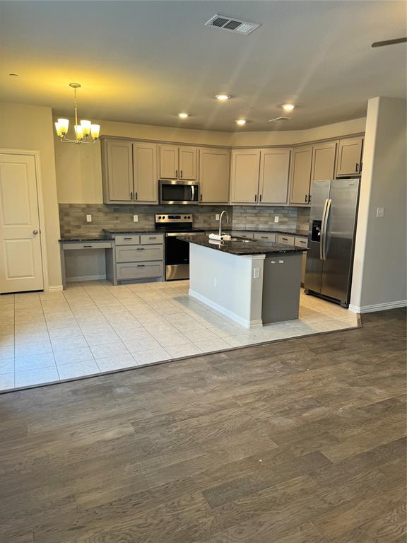 4475 Samarth Street Irving, TX 75061 - Photo 20 of 26 a large kitchen with a large counter top stainless steel appliances and cabinets