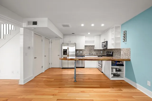 a kitchen with stainless steel appliances granite countertop a refrigerator and a stove top oven
