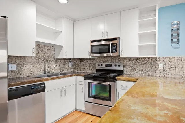 a kitchen with cabinets stainless steel appliances and a counter space