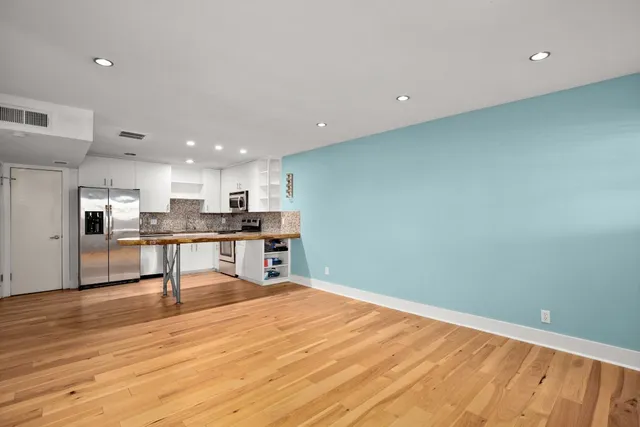 a view of kitchen with wooden floor and electronic appliances
