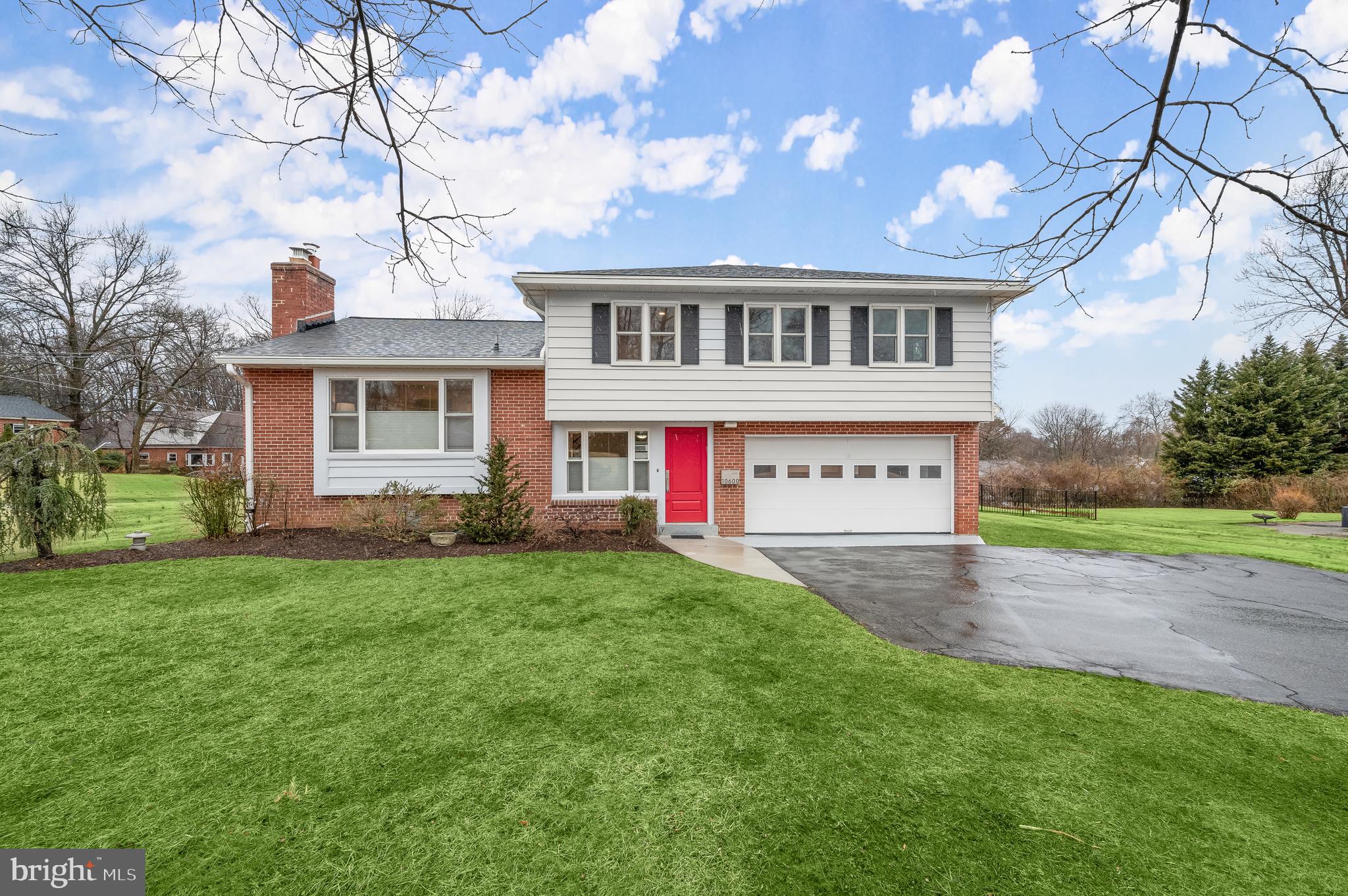 a front view of a house with a yard and trees