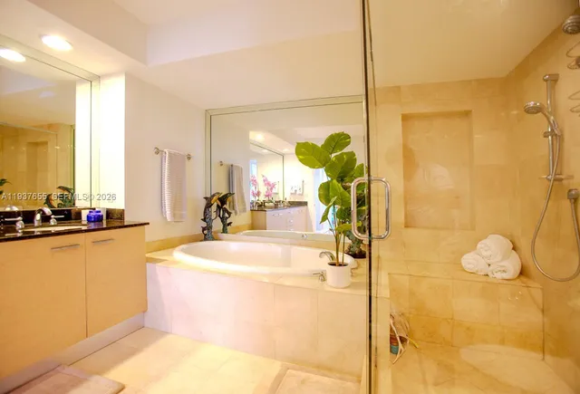 a bathroom with a tub sink and mirror