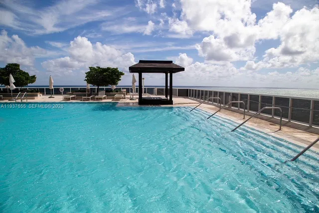 a view of a swimming pool with a table and chairs in the patio