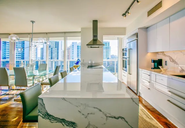 a kitchen with stainless steel appliances kitchen island granite countertop a table and chairs