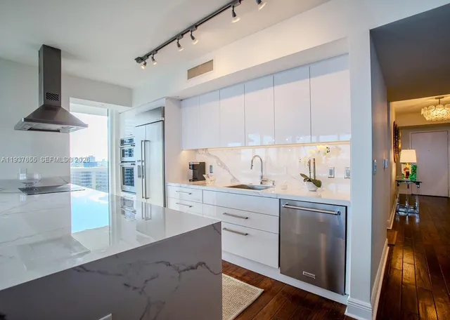 a kitchen with granite countertop white cabinets and white appliances