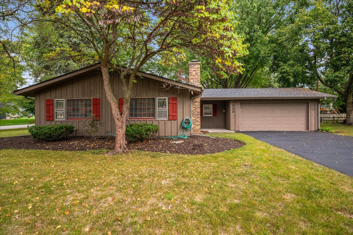 a front view of house with yard and trees around