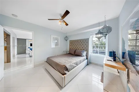 a bedroom with a large bed and ceiling fan
