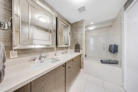 a spacious bathroom with a double vanity sink toilet mirror and bathtub