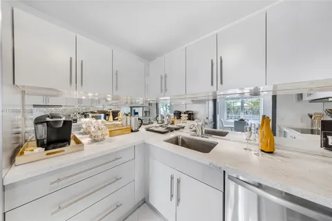 a kitchen with white cabinets and white appliances