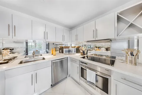 a spacious bedroom with a large bed and a chandelier