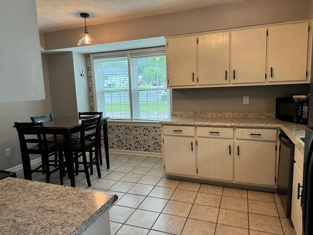 a kitchen with a table chairs and cabinets