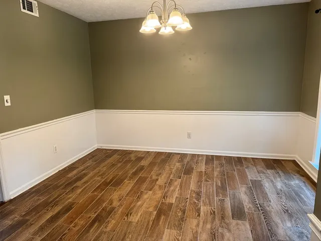 a view of a room with wooden floor and white walls
