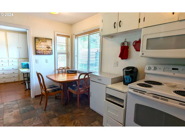 a kitchen with a stove a refrigerator and a dining table