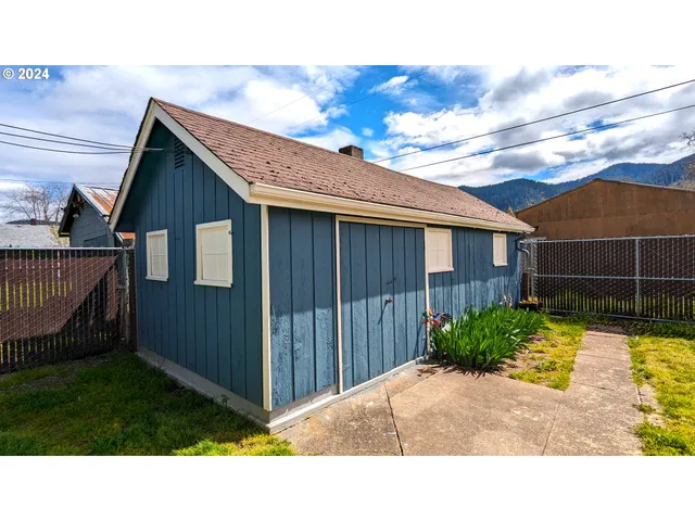 a view of backyard with potted plants and wooden fence