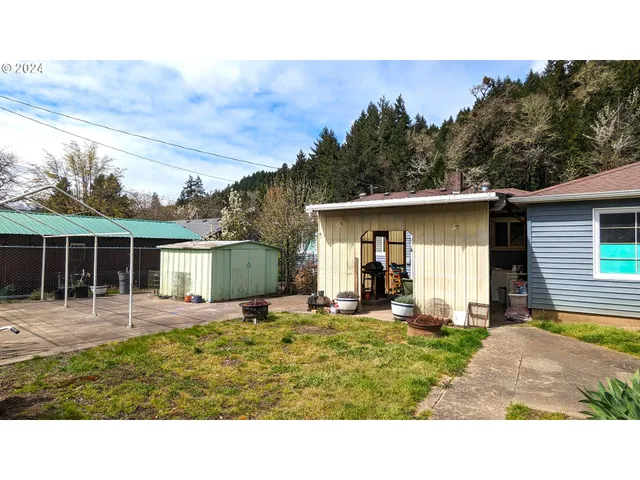 a backyard of a house with yard table and chairs